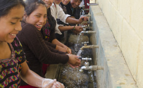 Students using the hand washing station with the APLS Circuit Rider for this area, Diego Rameriz, looking on.