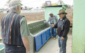 Head mason, Antonio Cavinatoma, talking with head of APSL, Lynn Roberts, while another mason checks the operation of the faucets of the new hand washing station at La Primavera School.